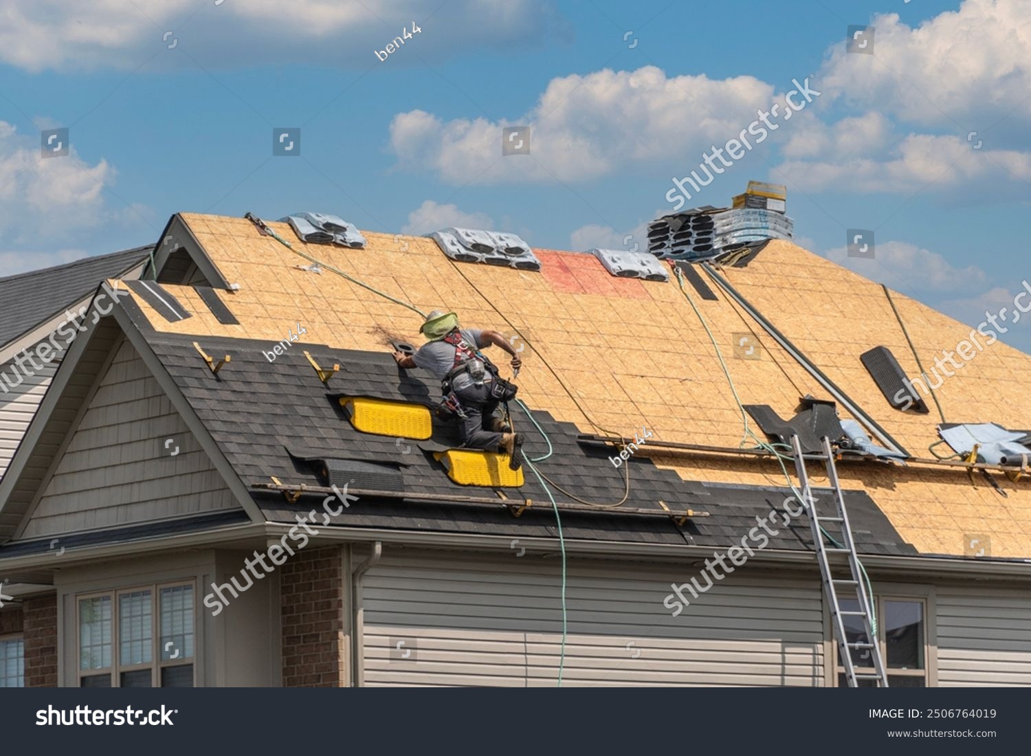 stock-photo-roofers-completely-replace-old-asphalt-shingle-roof-during-summer-in-canada-2506764019