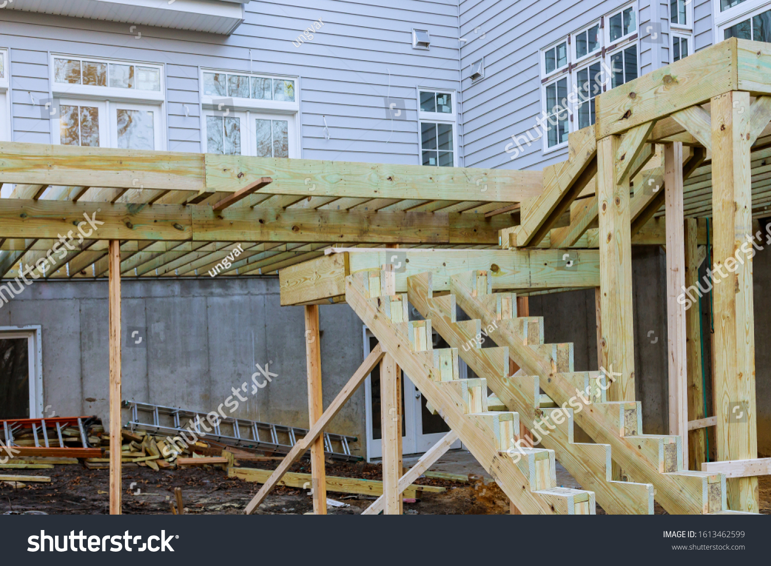 stock-photo-unfinished-installation-deck-patio-construction-of-flooring-by-new-house-1613462599